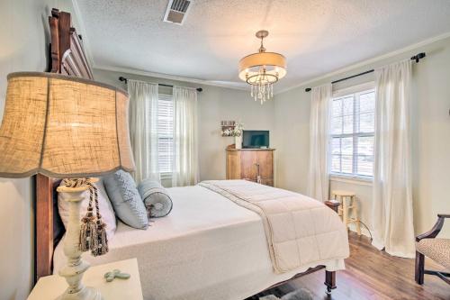 ein Schlafzimmer mit einem weißen Bett und einer Lampe in der Unterkunft Mississippi Cottage about 6 Mi to Columbus Lake in Columbus