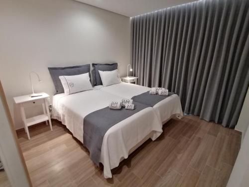 Apartments Madeira Barreirinha في فونشال: غرفة نوم بسرير كبير وعليها شمعتين