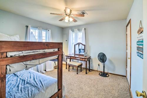 een slaapkamer met een bed, een plafondventilator en een bureau bij Incredible Log Home 1 Mile From Lake Tenkiller in Vian