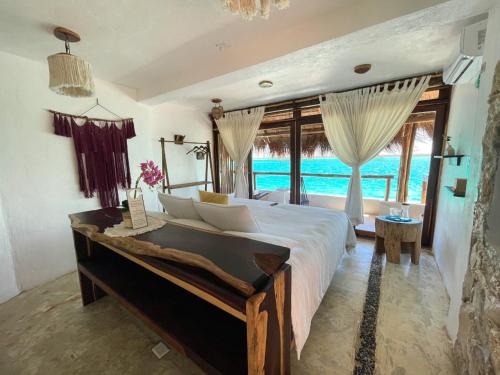 a bedroom with a large bed and a large window at Xcabal Hotel boutique in Bacalar