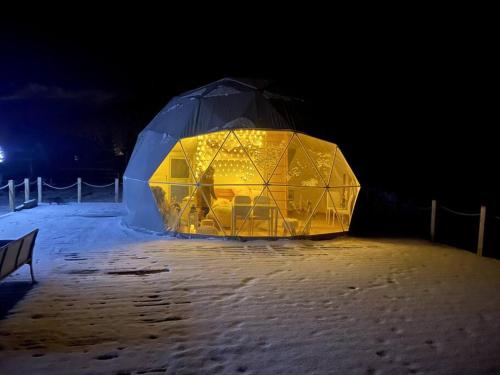an igloo is lit up in the snow at night at beautiful located dome in Wapnica