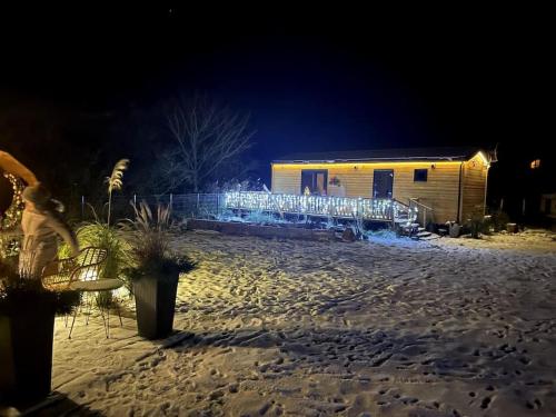 a house with christmas lights in the snow at night at Tiny beach house heated and airconditioned in Wapnica