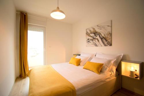 a bedroom with a large bed with yellow pillows at Apartment Nikola in Split