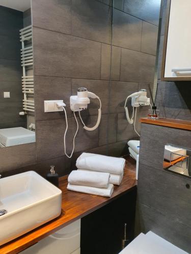 a bathroom with a sink and towels on a counter at Platinum Towers by City Apartments in Warsaw