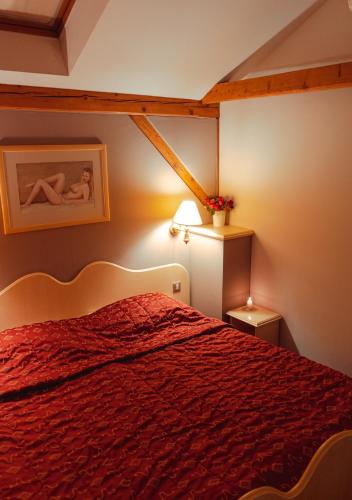 a bedroom with a bed with a red bedspread at Hotel & Restaurant Se-Mi in Veliko Trgovišće