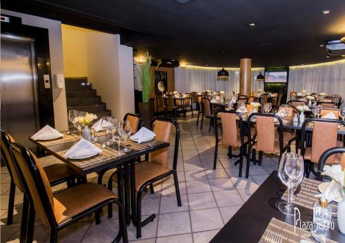 ein Restaurant mit Tischen und Stühlen mit Weingläsern in der Unterkunft Lord Plaza Hotel in Teixeira de Freitas