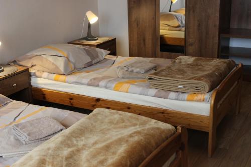 1 dormitorio con 2 camas y espejo en Dom Pielgrzyma, en Toruń