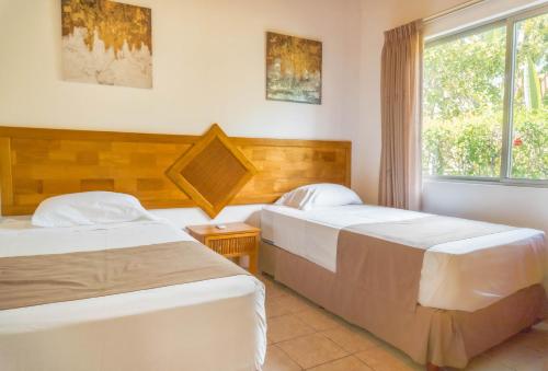 a bedroom with two beds and a window at Sueño al Mar Residence & Hotel in Potrero