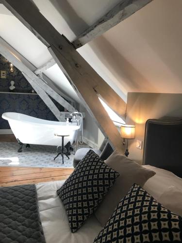 a bedroom with a bed and a bath tub at Chambres d'hôtes du château in Boulogne-sur-Mer