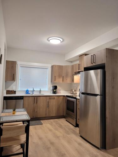 a kitchen with wooden cabinets and a stainless steel refrigerator at Feel like Home! in Langford