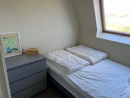 - une chambre avec un lit, une commode et une fenêtre dans l'établissement Vakantiehuisje aan zee vlakbij Plopsaland en het strand - Casa Memphis, à La Panne