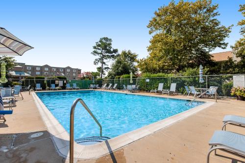 a large swimming pool with chairs and a fence at Sea Pines Village --- 8 Sea Pines Village in Bethany Beach
