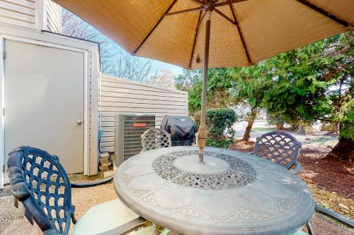 a table with an umbrella on a patio at Sea Pines Village --- 8 Sea Pines Village in Bethany Beach