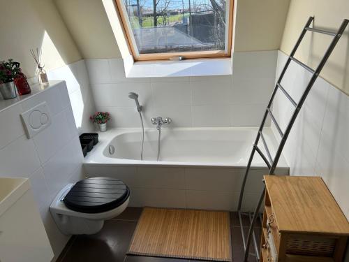 ein kleines Bad mit einem WC und einer Badewanne in der Unterkunft Vakantiehuisje aan zee vlakbij Plopsaland en het strand - Casa Memphis in De Panne