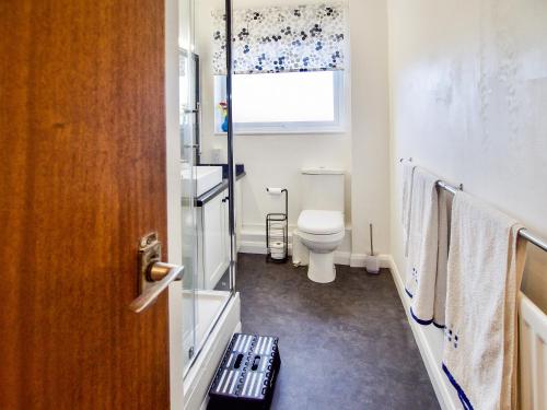 een badkamer met een toilet, een wastafel en een raam bij Galley Hill Aspect in Bexhill