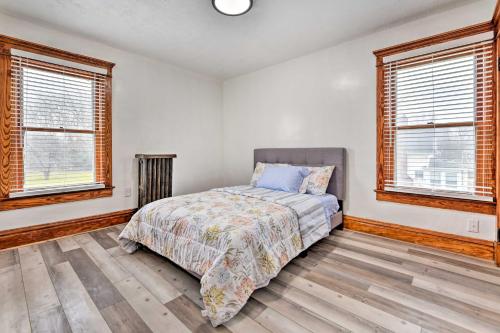 a bedroom with a bed and two windows at Vacation Rental about 2 Mi to Highmark Stadium! in Buffalo