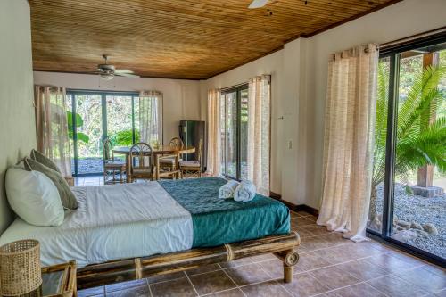 sypialnia z łóżkiem, stołem i krzesłami w obiekcie Guapil #10 w mieście Dominical
