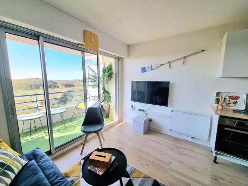 a living room with a couch and a large window at T2 cozy face dunes et océan - Thalasso et golf in Saint-Jean-de-Monts