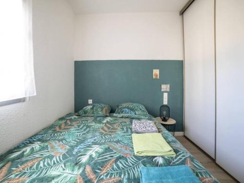 une chambre avec un lit avec une couette colorée dans l'établissement T2 face dunes et ocean - Proche Golf et Thalassothérapie, à Saint-Jean-de-Monts