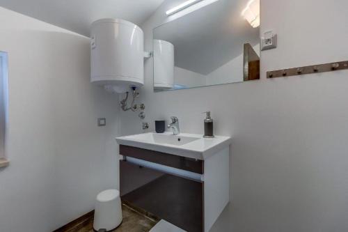 a white bathroom with a sink and a mirror at Meer in Nerezine