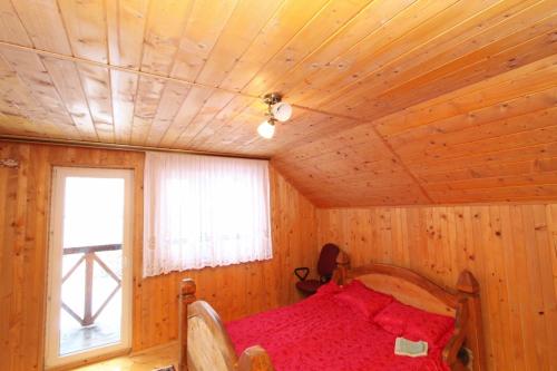 a bedroom with a bed in a log cabin at Багрівчанка in Yaremche