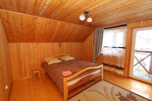 a bedroom with a bed in a wooden cabin at Багрівчанка in Yaremche