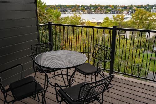 a table and chairs on a balcony with a view at The Earl in Charlevoix in Charlevoix
