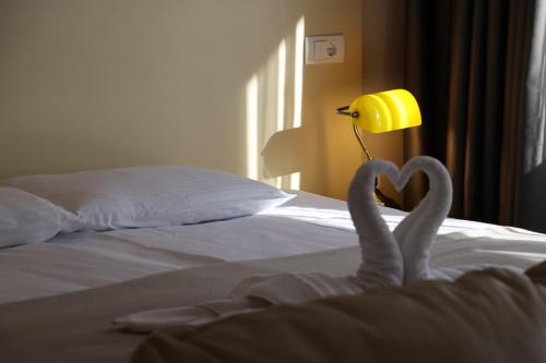 a pair of swans making a heart on a bed at Hotel Happy in Dimitrovgrad