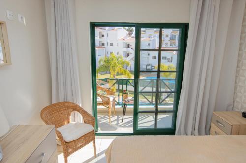 een slaapkamer met een groot raam met uitzicht op een patio bij Holiday Albufeira in Albufeira
