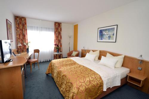 ハンブルクにあるHotel Panorama Hamburg-Billstedtのベッドとデスクが備わるホテルルームです。