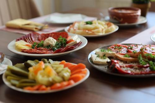 a wooden table with plates of food on it at Hotel Happy in Dimitrovgrad