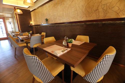 a restaurant with a wooden table and chairs at Hotel Happy in Dimitrovgrad