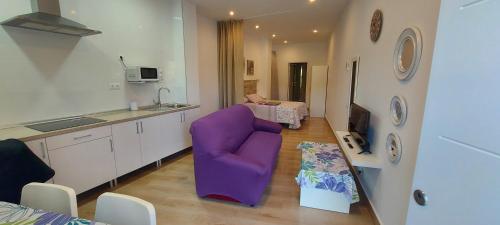 eine Küche mit einem lila Stuhl in einem Zimmer in der Unterkunft La casita de Margo 1 in Málaga