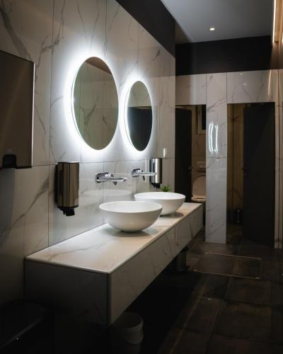 a bathroom with two sinks and two mirrors at Hotel & Restaurant Se-Mi in Veliko Trgovišće