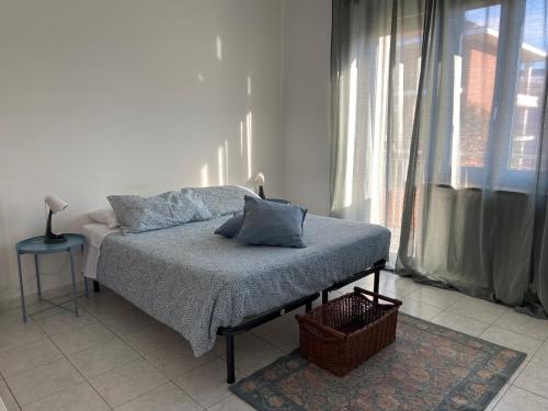 Guest House MICINI في Druento: سرير في غرفة بيضاء مع نافذة