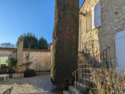ein Gebäude mit einer Treppe neben einem Baum in der Unterkunft Chambre chez Manon en Luberon in Lagnes