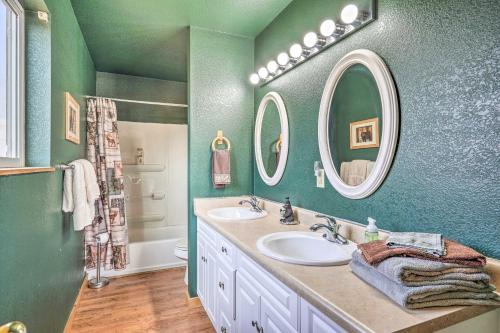 Baño verde con 2 lavabos y 2 espejos en Rustic Cabin on 4 Acres with Deck, Grill and Mtn View!, en Florissant