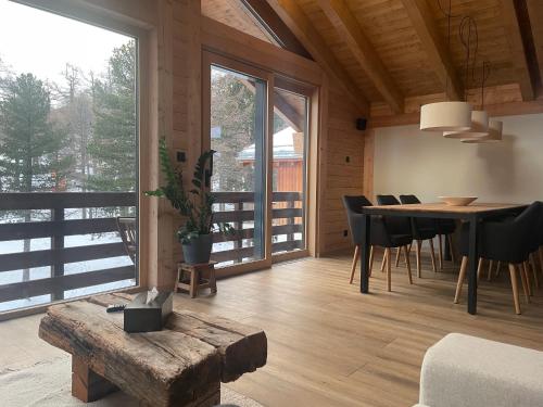 a living room with a table and chairs and a large window at Chalet Tannegg in Saas-Fee
