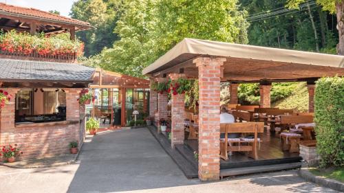 un edificio de ladrillo con un patio con mesas y sillas en Hotel & Restaurant Se-Mi, en Veliko Trgovišće