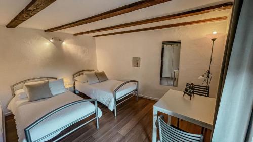 Kleines Zimmer mit 2 Betten und einem Tisch in der Unterkunft B&B ALLA PIAZZETTA DI TEGNA in Tegna