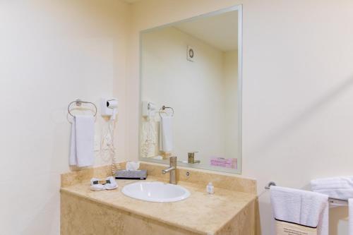 a bathroom with a sink and a large mirror at Mision Puebla Angelopolis in Puebla