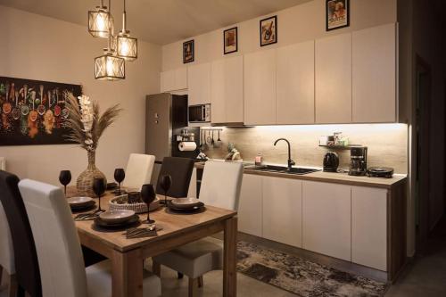 a kitchen with a wooden table and white cabinets at Villa Filarety Luxury House in Thessaloniki