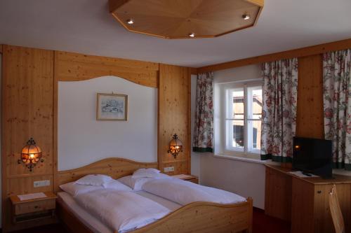 a bedroom with a large bed with white sheets at Waldgasthof Passegger in Sankt Andrä im Lungau
