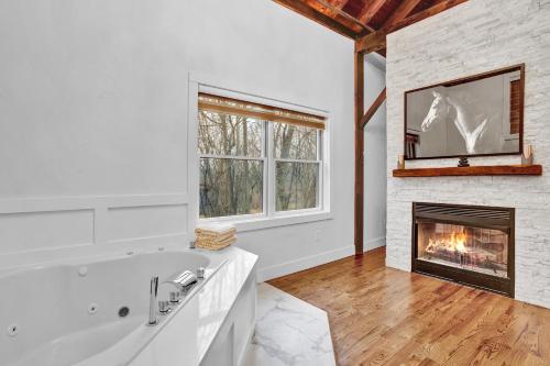 a bathroom with a white tub and a fireplace at Chimney Hill Estate Inn in Lambertville