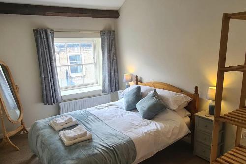 a bedroom with a bed with two towels on it at Lovely 2 bedroom apartment in Kendal town centre in Kendal