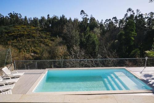 uma piscina numa varanda com cadeiras e árvores em Quinta do Sol - Holiday Home in Gerês em Arcos de Valdevez
