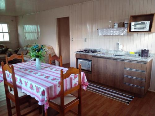 a kitchen with a table with a vase of flowers on it at Hospedagem Alternativa Ana Nazarete in São Joaquim