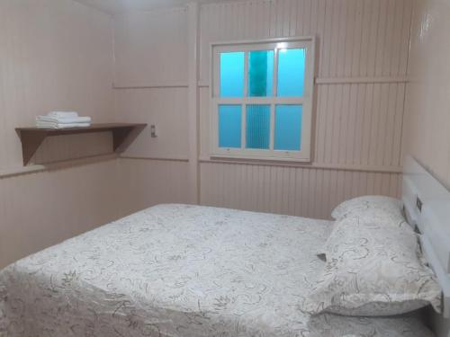 a small bedroom with a bed and a window at Hospedagem Alternativa Ana Nazarete in São Joaquim