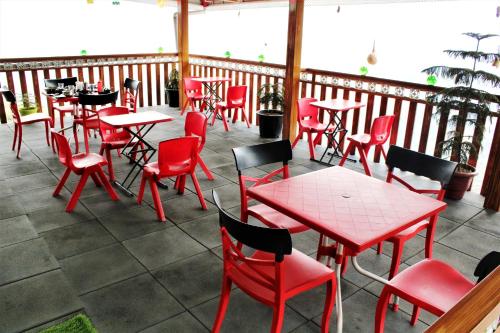 a restaurant with red tables and chairs on a patio at Hotel Forest View and Restaurant in Mussoorie