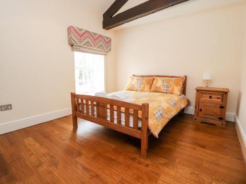 a bedroom with a wooden bed and a window at Hudson in Lancaster